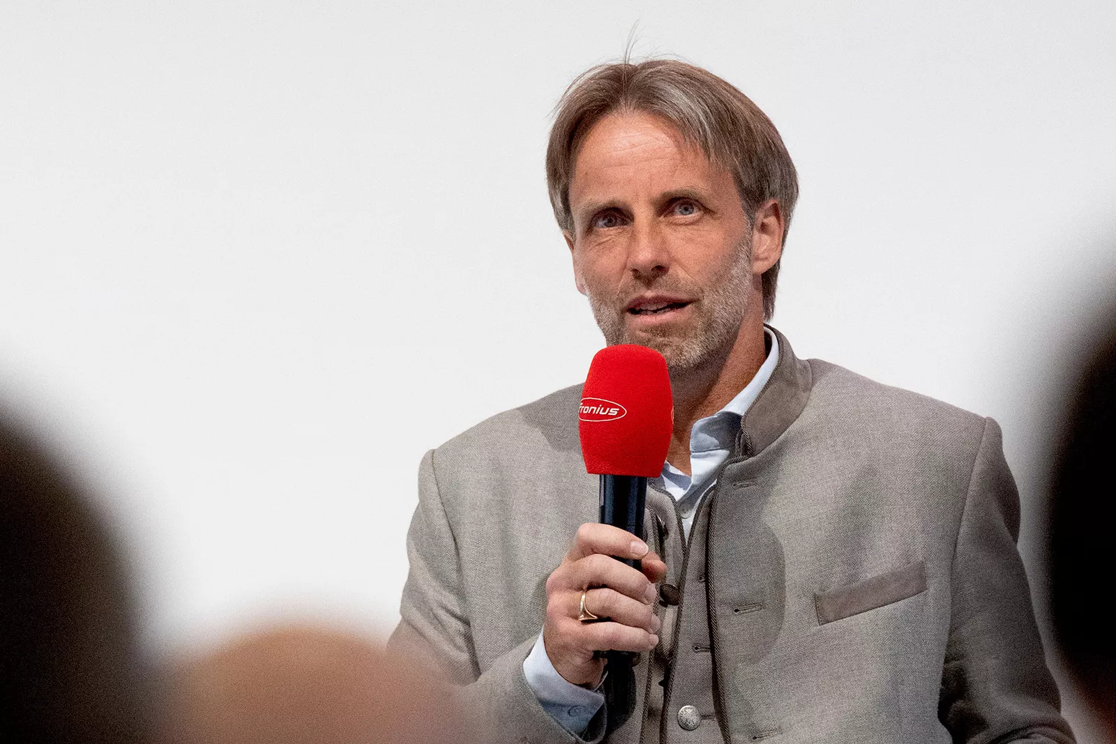 Mann moderiert mit einem Mikrofon
