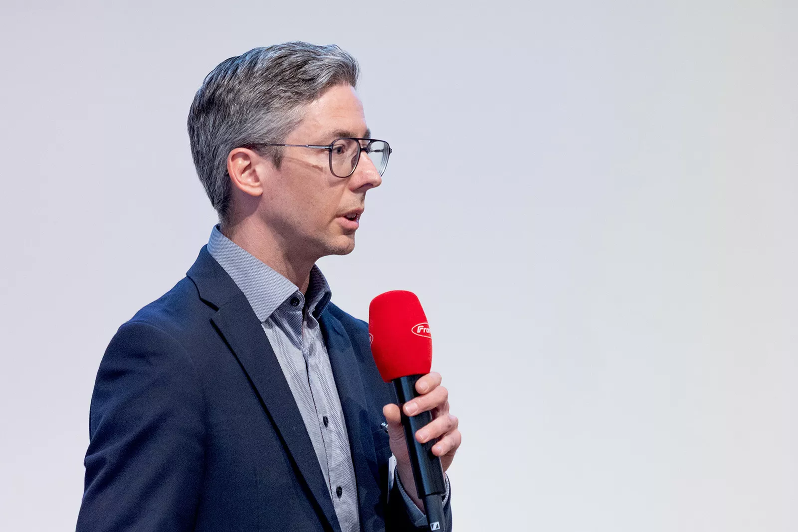 Mann moderiert mit einem Mikrofon