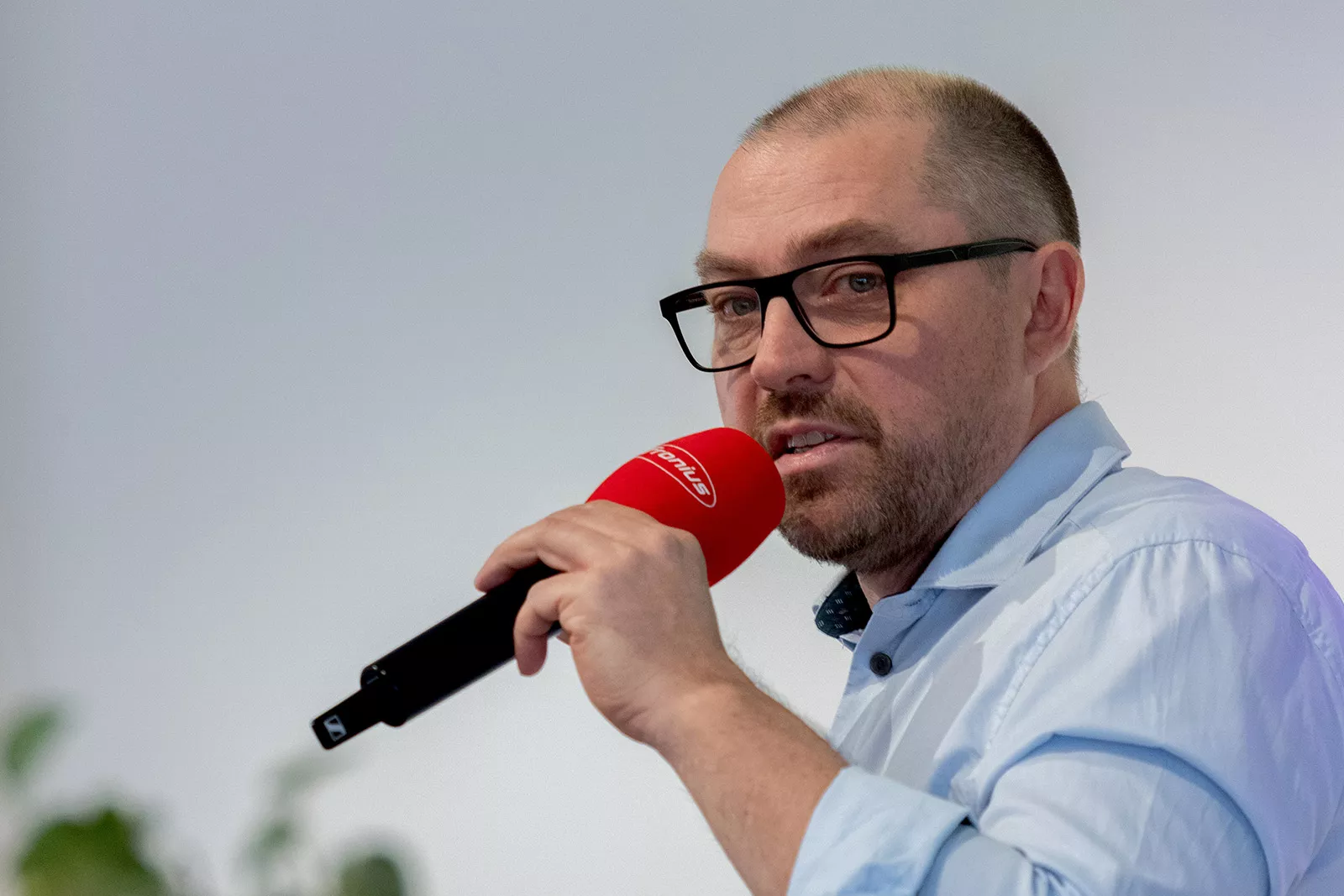 Mann moderiert mit einem Mikrofon