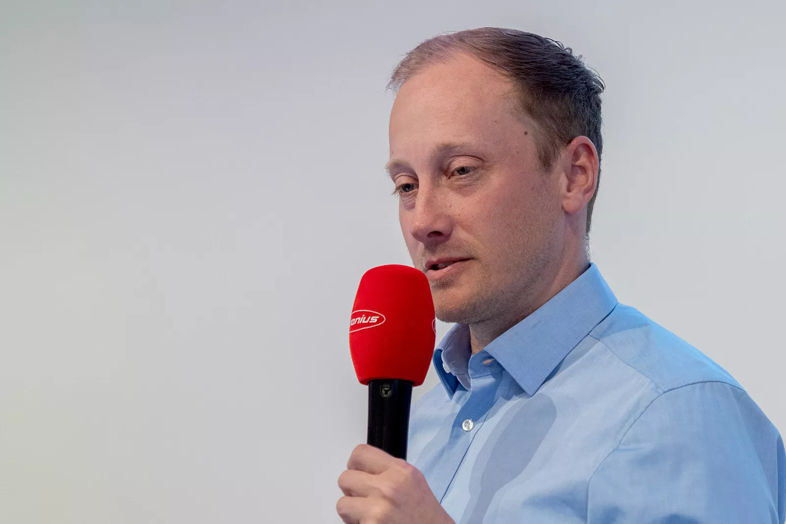 Mann moderiert mit einem Mikrofon